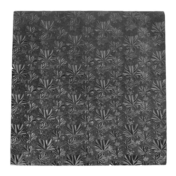 A white square cake drum with a black pattern on top.