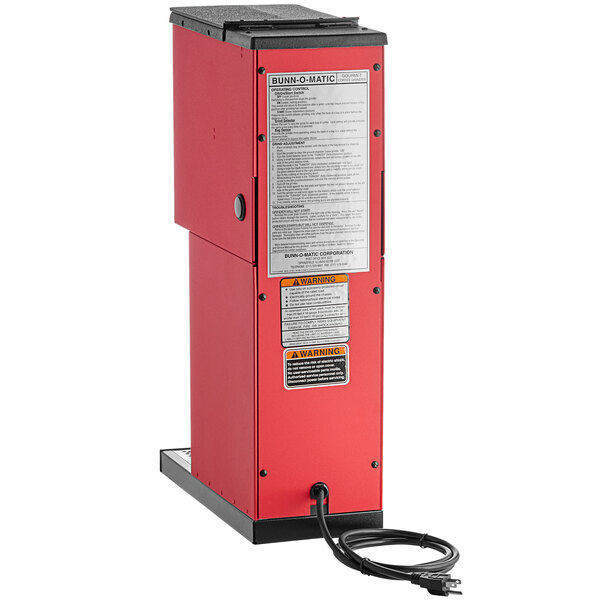 A red rectangular Bunn coffee grinder with a black cord.
