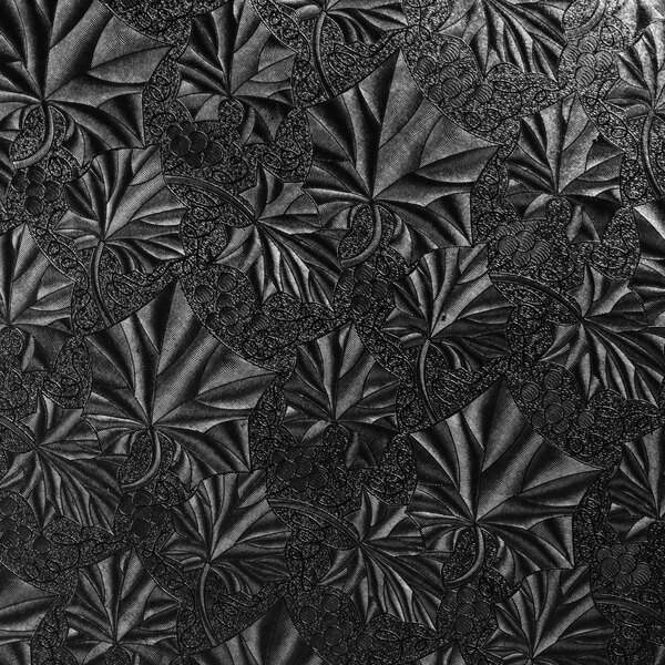 A black and white photo of a patterned background on a black cake drum.