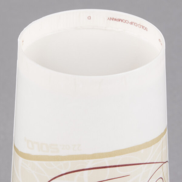A close up of a white Solo paper cold cup with brown design.