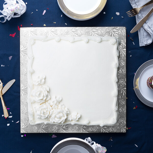 A white square cake on a silver Enjay cake board.