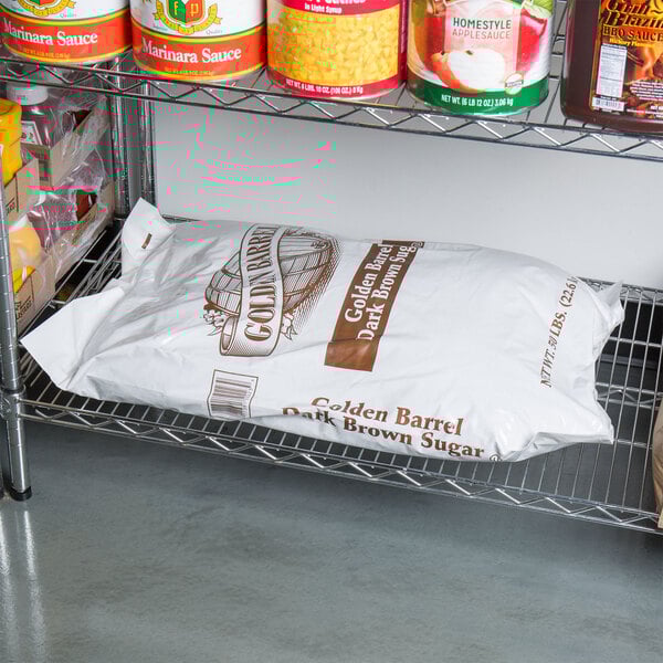 A metal shelf in a grocery store aisle with a bag of Golden Barrel Dark Brown Sugar.