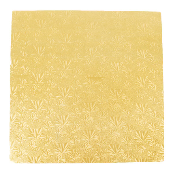 A close up of a gold square Enjay cake drum with floral designs on the surface.