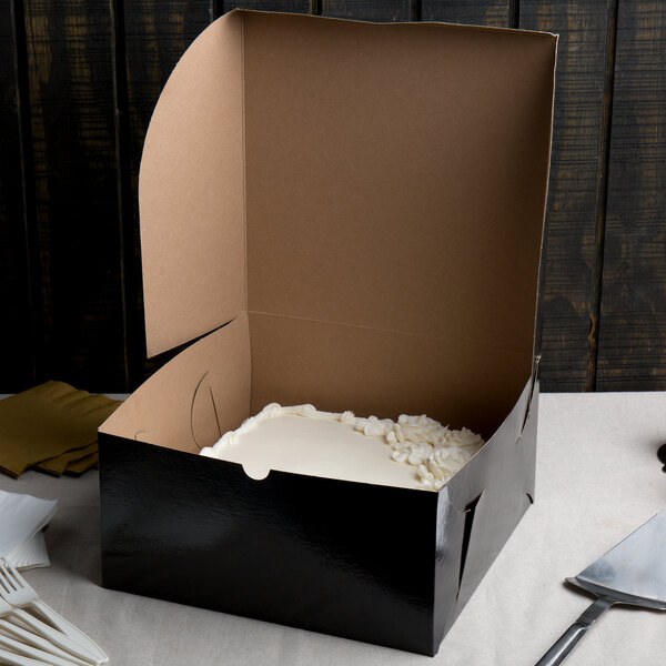 A black Enjay cake box with a cake inside.