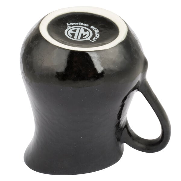 An American Metalcraft black porcelain bell creamer with a white rim and handle.