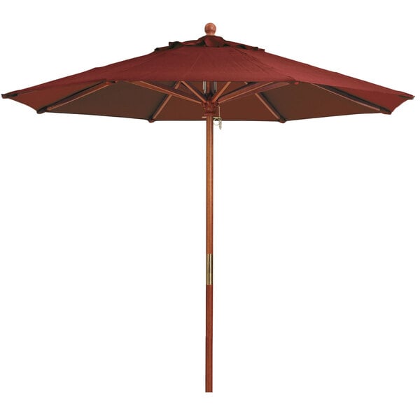 A Grosfillex burgundy market umbrella with a wooden pole.