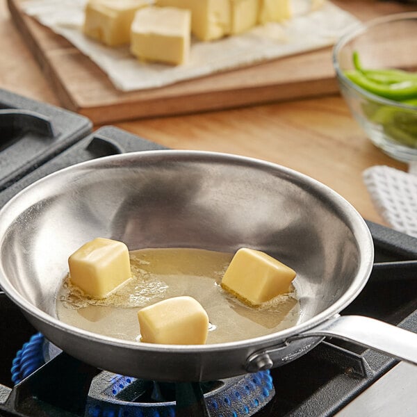 A pan with Alpine Valley margarine in it on a stove.