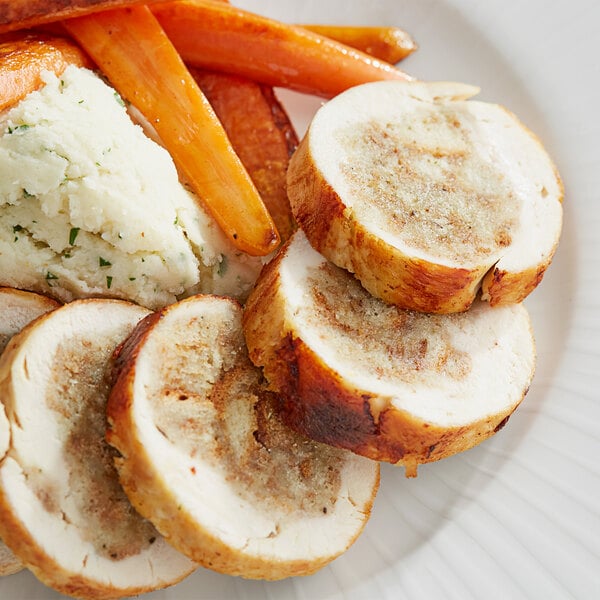 A plate of food with Pepperidge Farm herb seasoned stuffing, meat, and vegetables on a white surface.