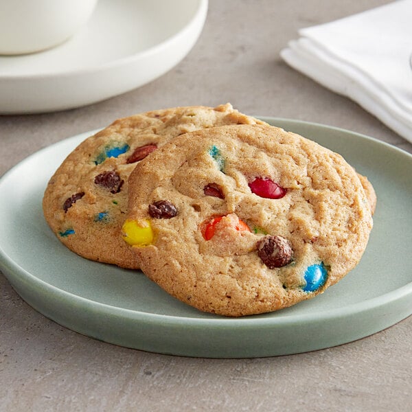 Two David's Cookies M&M's chocolate chip cookies on a plate.
