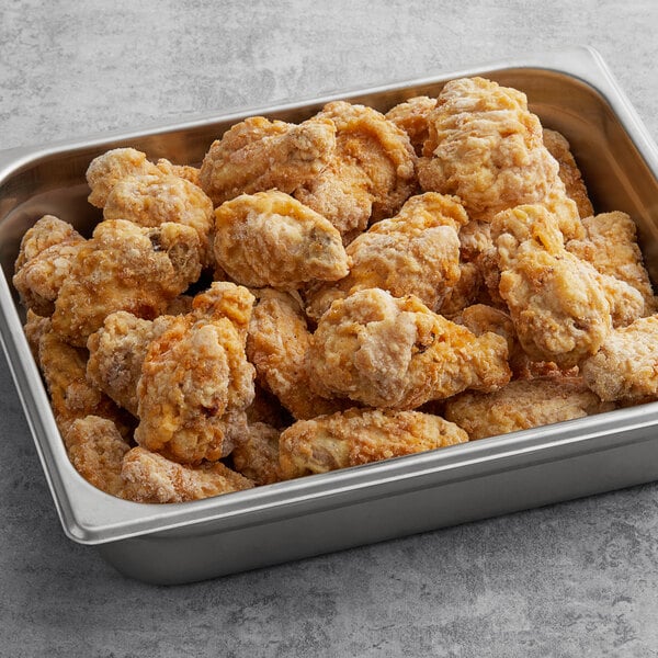 A metal pan of Brakebush Wing-Ditties breaded chicken wings.
