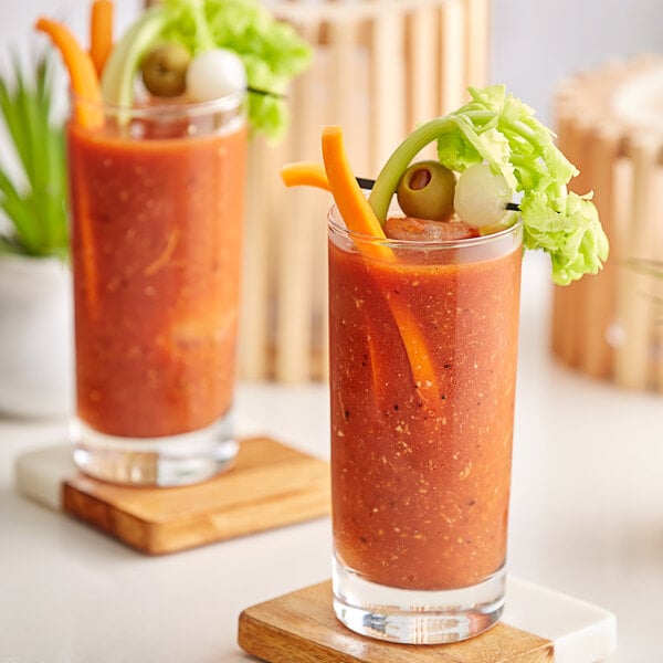 A close up of two glasses of V8 Original Vegetable Juice with olives.