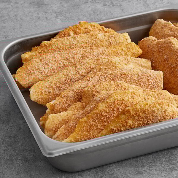 A pan filled with Colony Lane precooked breaded flounder portions.