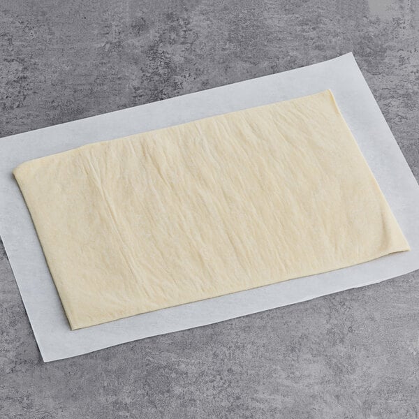 A Pennant French puff pastry dough sheet on white paper.
