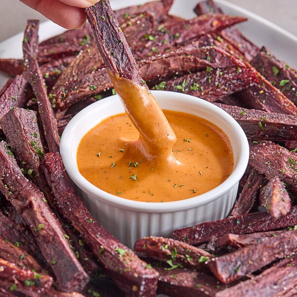 A bowl of Hellmann's Real Ancho Chipotle Sauce with a plate of food for dipping.