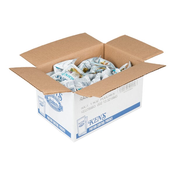 An open cardboard box filled with individually packaged condiment pouches.