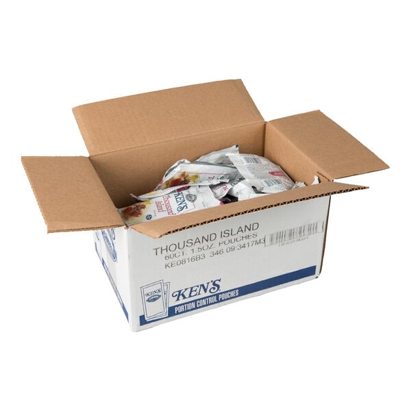 An open cardboard box containing multiple small packets labeled as Thousand Island dressing.