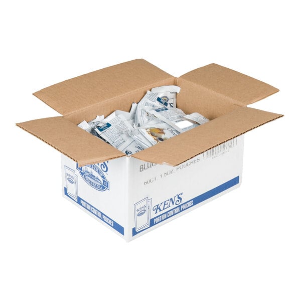 An open cardboard box containing multiple individually packaged condiment pouches.