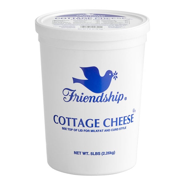 A white Grassland container of small curd cottage cheese with blue text and a blue bird.