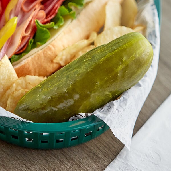 A plate with a sandwich and a B&G San-Del whole kosher dill pickle.