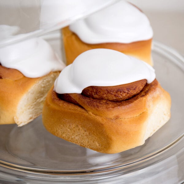 A close-up of a David's Cookies Old Fashioned Iced Cinnamon Roll with white frosting.