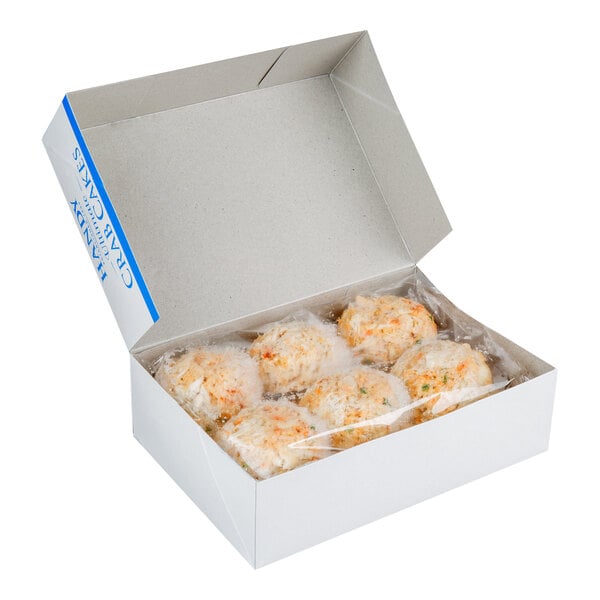 A white box of Handy 4 oz. Ultimate Crab Cakes with plastic wrap over them.