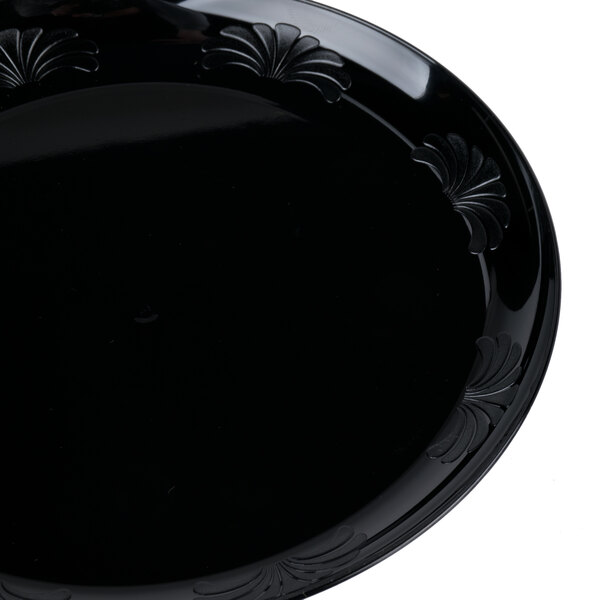 A black plastic WNA Comet Designerware plate with a design.