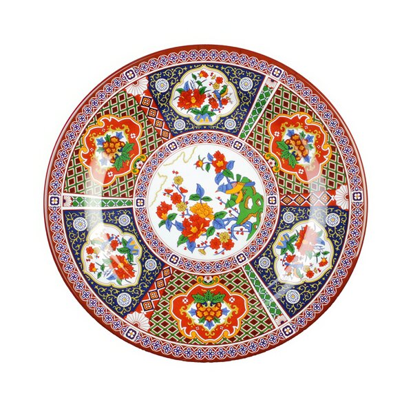 A close-up of a colorful Thunder Group Peacock melamine plate with floral designs of peacocks and flowers.