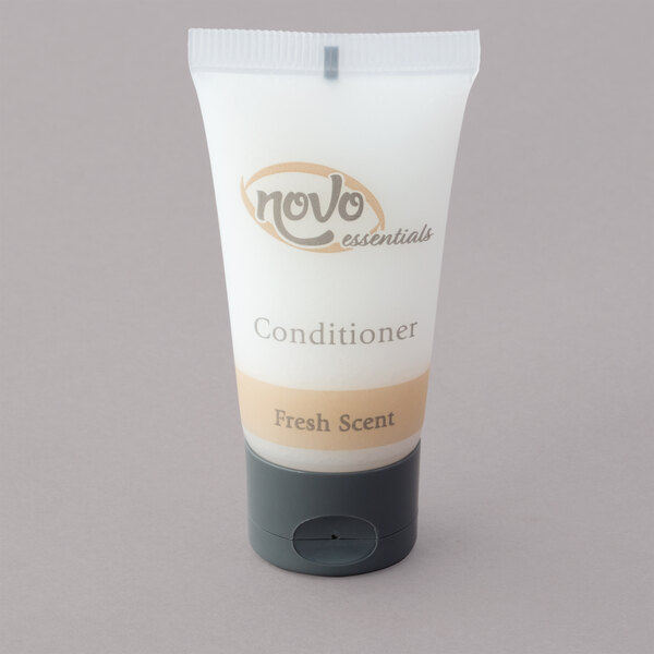 A white plastic container of Novo Essentials hotel conditioner with a brown label.