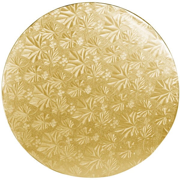 A white and gold round cake drum with a leaf pattern.