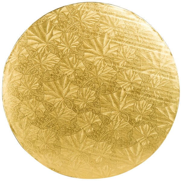 A circular gold plate with leaves on it.