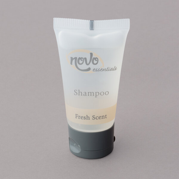 A white plastic bottle of Novo Essentials Hotel and Motel Shampoo with a white label.