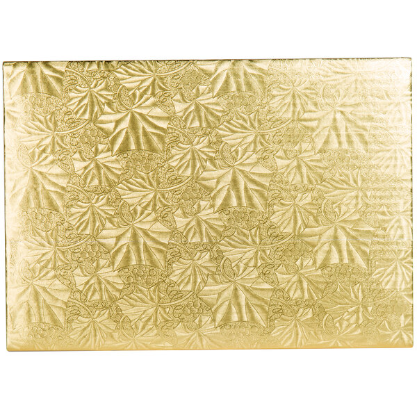 A gold rectangular Enjay cake board with leaves on it.