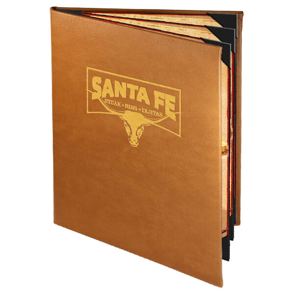 A brown leather Menu Solutions Bella Collection menu cover with a logo in gold on a table in a Mexican restaurant.