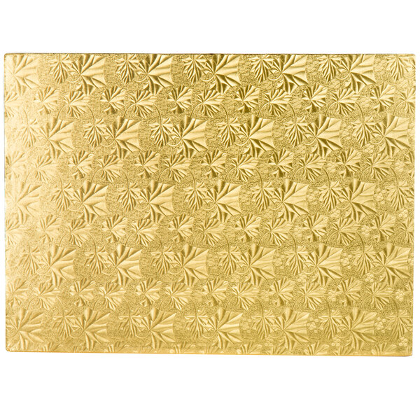 A gold cake board with a patterned surface.