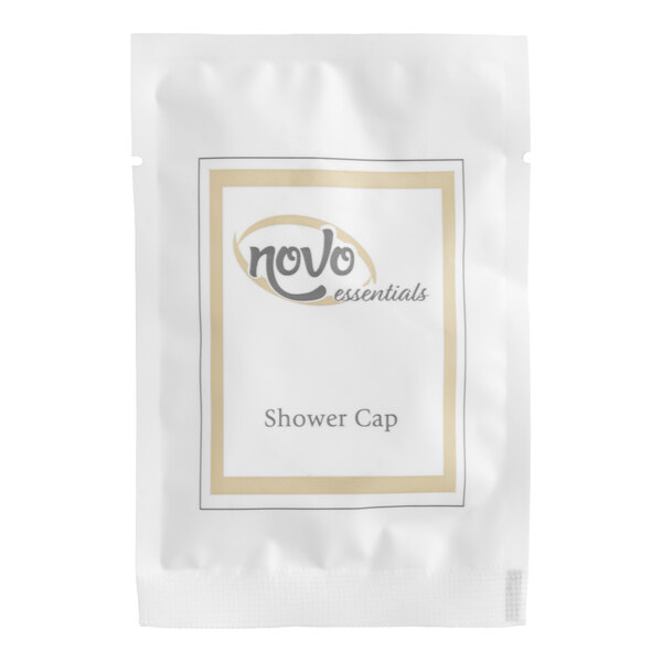 A white packet labeled 'Novo Essentials Shower Cap' containing a hotel and motel shower cap.