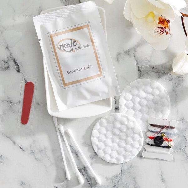 A Novo Essentials hotel grooming kit on a counter next to a white flower.