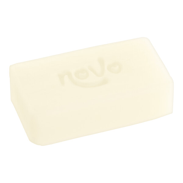 A white rectangular Noble Eco Novo hotel soap bar wrapped in white with the word "Natura" on it.