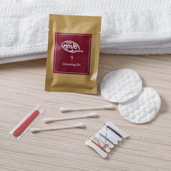 A white towel and a pack of cotton pads and cotton swabs on a table.