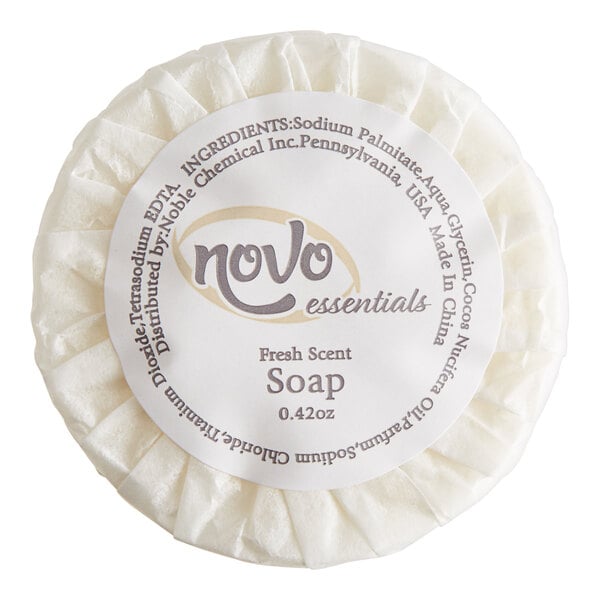 A round white Novo Essentials bath soap bar in white wrapping with black text.