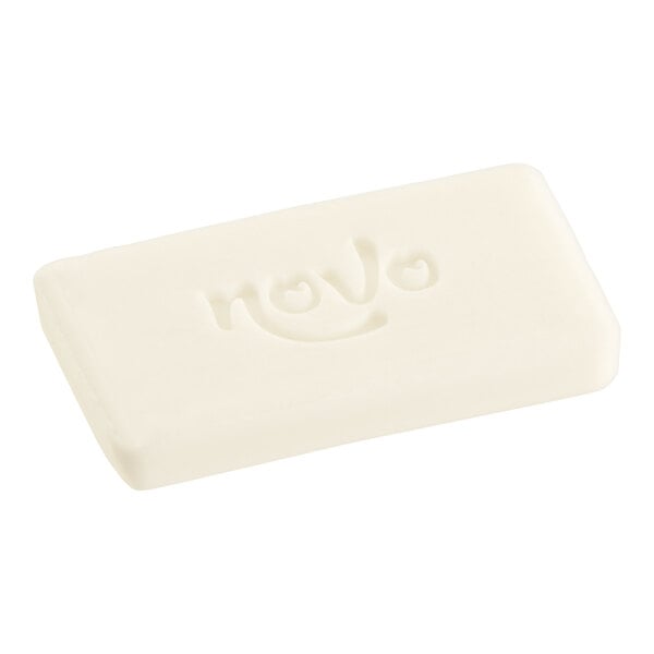 A white rectangular Novo Essentials facial soap bar wrapped in white paper.