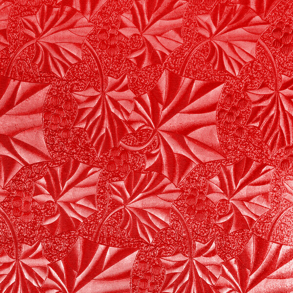 A white square cake drum with a red surface and leaf pattern.