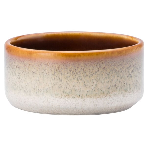 A close up of a Oneida Rustic Sama porcelain ramekin with brown and white speckles.