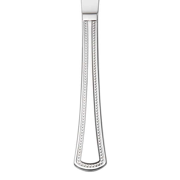 An Oneida Needlepoint stainless steel dinner knife with a white handle.