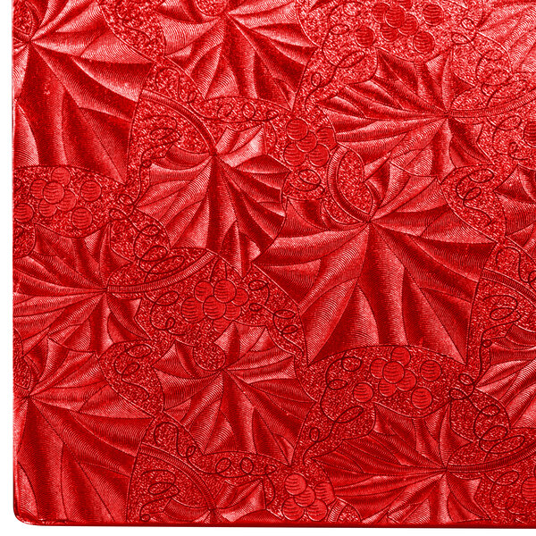 A white square cake drum with a red fabric pattern on top.