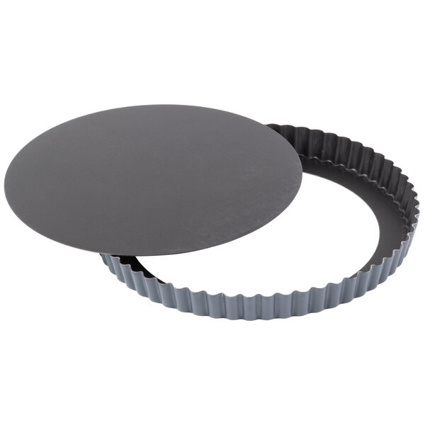 A round black tart pan with a round bottom.