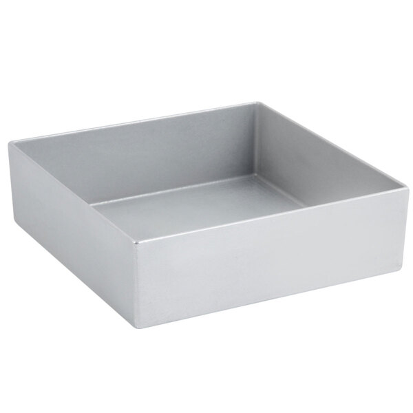 A silver square Bon Chef bowl with a lid on a white surface.