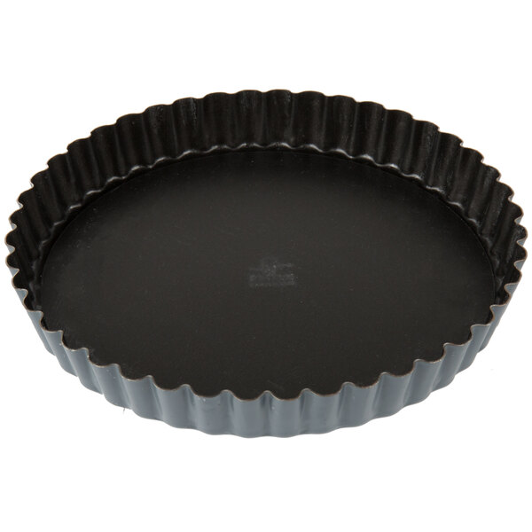 A black Matfer Bourgeat fluted non-stick tart pan with a removable bottom.