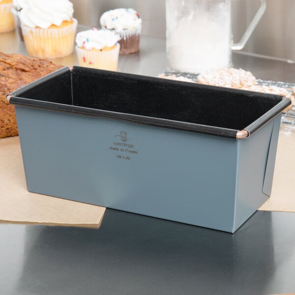 A Matfer Bourgeat metal loaf pan with a loaf of bread in it.