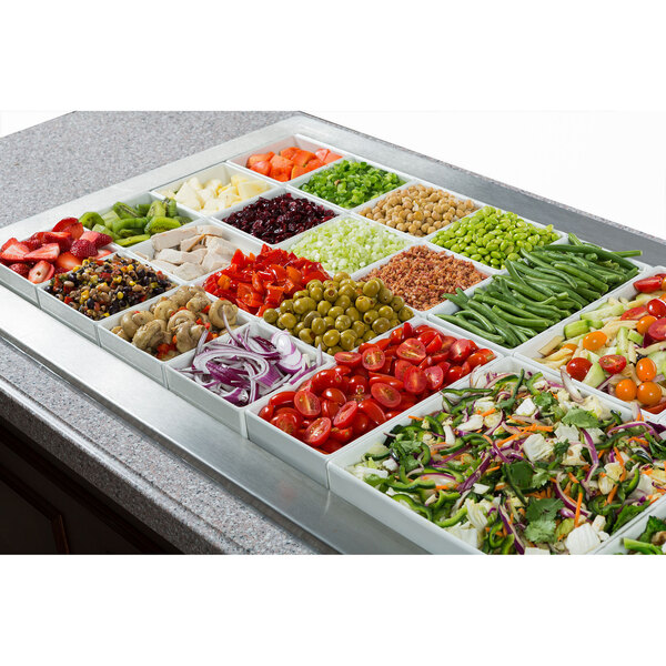 A white sandstone finish square bowl filled with tomatoes on a salad bar counter.
