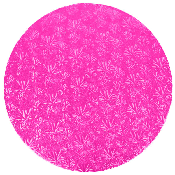 A pink round cake on a pink Enjay cake board with a pattern.